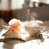 teacup on book beside pink flower decor